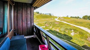 Ein Zimmer mit Blick auf eine grüne Landschaft, einer Holzbank und einem Fenster.