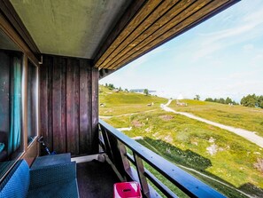 Ett rum med utsikt över ett grönskande landskap, en träbänk och ett fönster.