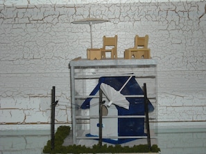 Una maqueta de un edificio con ventana, una silla y una mesa.