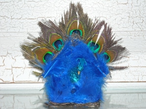 Un tocado con forma de pavo real, con plumas azules y verdes.