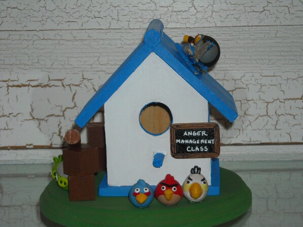 A birdhouse with a sign that reads "ANGER MANAGEMENT CLASS".