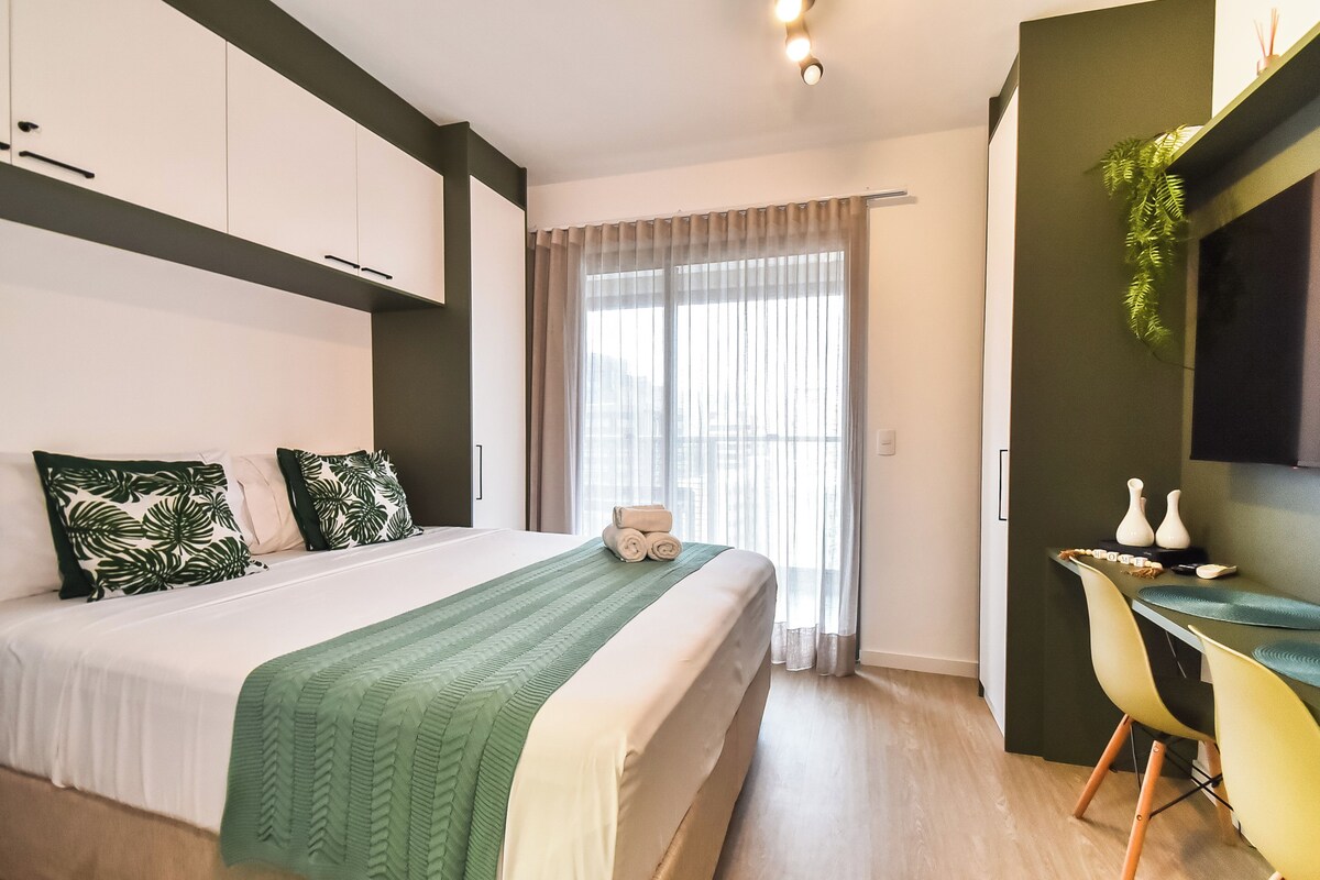Quarto moderno com cama, escrivaninha e janela com cortinas.