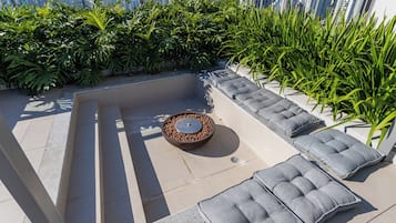 Une terrasse sur le toit, dotée d’un espace salon, d’un foyer et offrant une vue sur le panorama urbain.