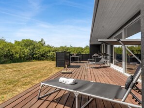 A wooden deck with a lounge chair, a barbecue grill, and a table with chairs. - "Tuva" - 3.5km from the sea by Interhome (Brovst)