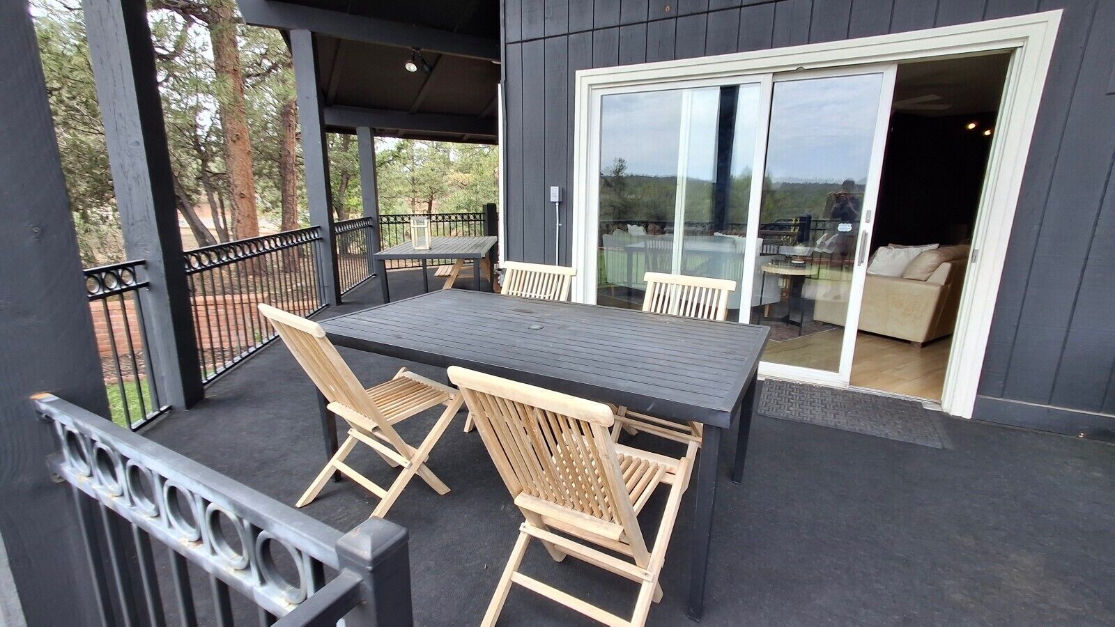 Eine Terrassengruppe mit Tisch und Stühlen, eine Glastür, die zu einem Raum führt, und ein Blick ins Freie.
