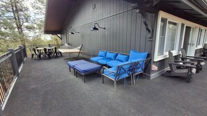 Un espacio de estar al aire libre cubierto con un sofá, sillas y mesas.