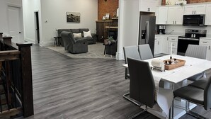 A modern kitchen with white cabinets, a stainless steel refrigerator, and a microwave. - Adorable 2-bedroom apartment with jetted Jacuzzi tub adjacent to Coffee Shop! (Brookfield)