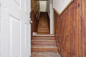 Una escalera de madera que lleva a una puerta blanca.