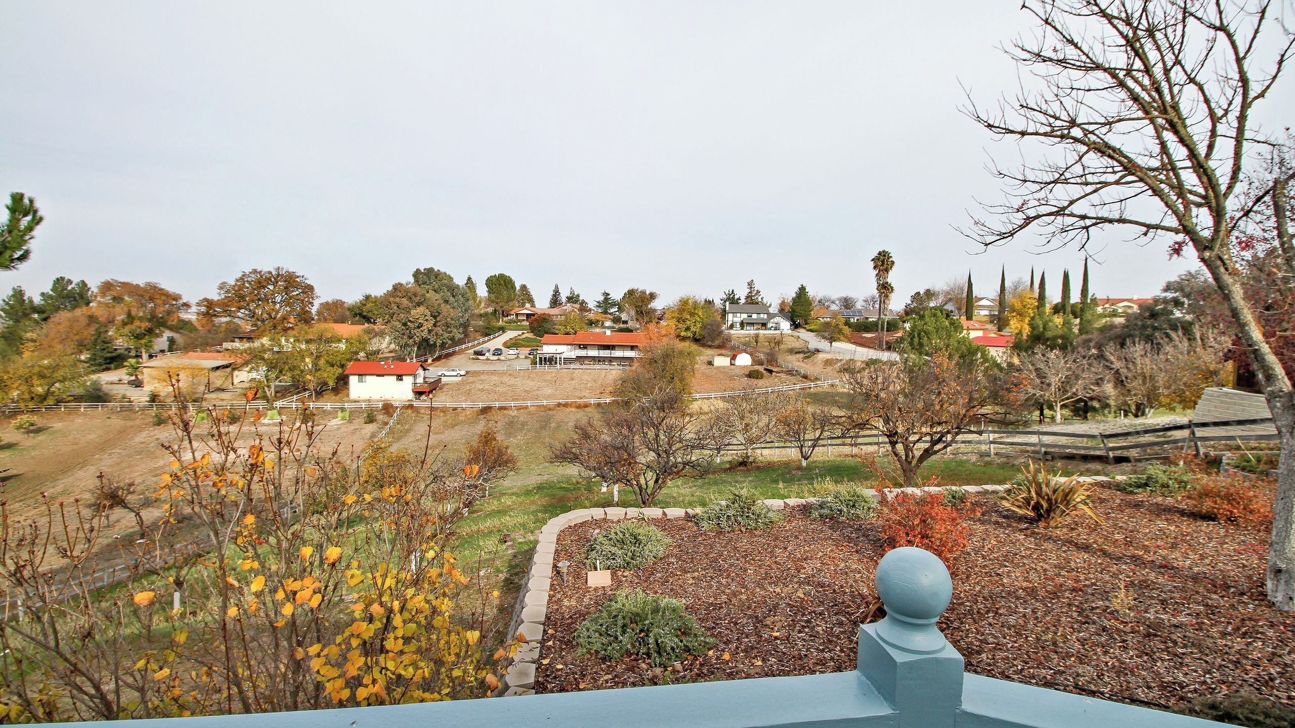 Un barrio residencial con casas, un patio cercado y cielo despejado.