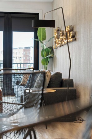 Ein modernes Wohnzimmer mit einer Couch, einem Couchtisch, einer Stehlampe und einer Wandleuchte.