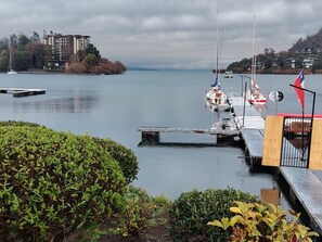 Ein Yachthafen mit vertäuten Booten, eine Anlegestelle, die ins Wasser führt, und ein Gebäude im Hintergrund.
