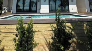 Um edifício de dois andares com uma piscina em frente.