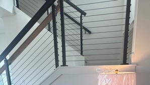 Um quarto com um armário de madeira, uma luminária e uma escada.