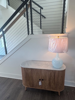 Ein Zimmer mit einem Holzkasten, einer Lampe und einer Treppe.