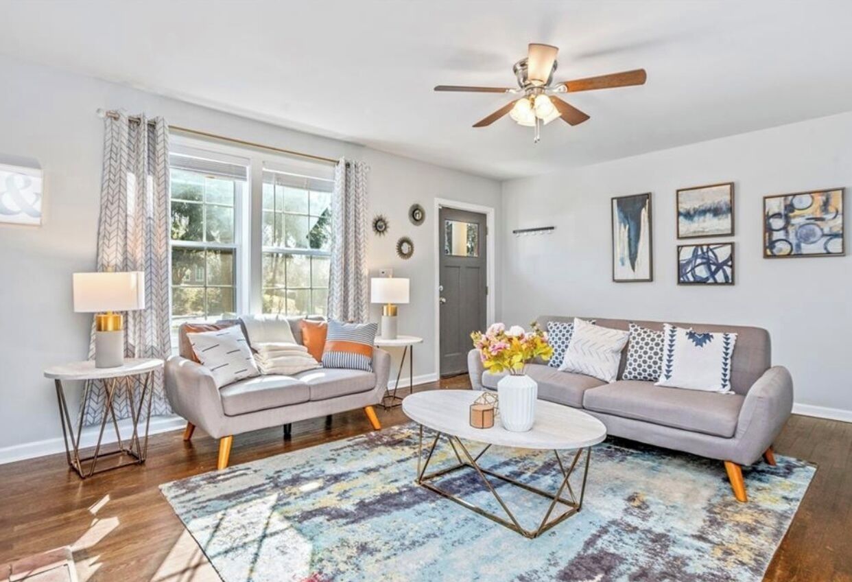 A living room with two sofas, a coffee table, and a ceiling fan.
