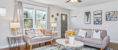 A living room with two sofas, a coffee table, and a ceiling fan.