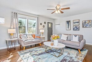 Ein Wohnzimmer mit zwei Sofas, einem Couchtisch und einem Deckenventilator.