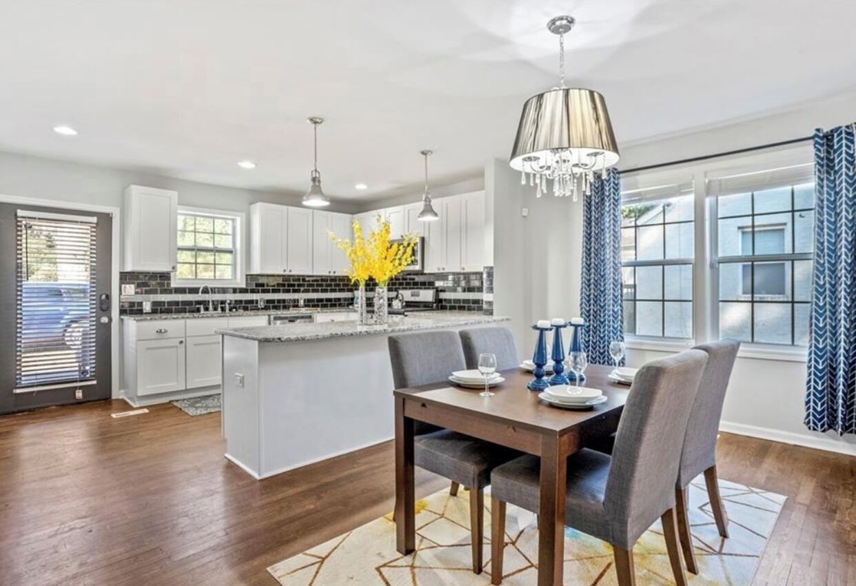 A modern kitchen with white cabinets, a central island, and pendant lighting.