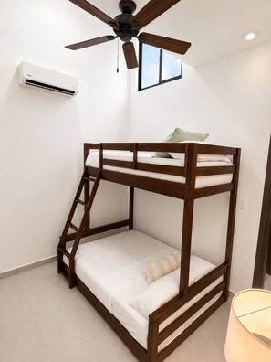 A bunk bed with a wooden frame, a ceiling fan, an air conditioning unit, and a window. - Casa Esmeralda Luxury Retreat (Jacó)