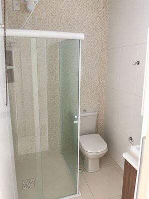Ein Badezimmer mit Duschkabine, Toilette und Waschbecken.