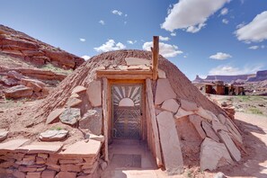 A traditional stone hut with a wooden door and a small entrance. - Base Camp Adventure Lodge (Moab)
