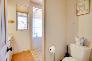 A bathroom with a toilet, a bidet, a window with blinds, and a picture on the wall. - Base Camp Adventure Lodge (Moab)
