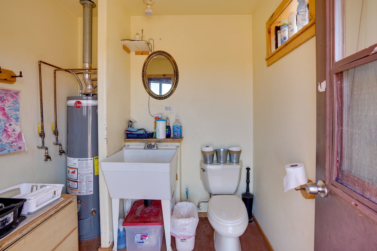 A compact bathroom with a toilet, sink, and a water heater.