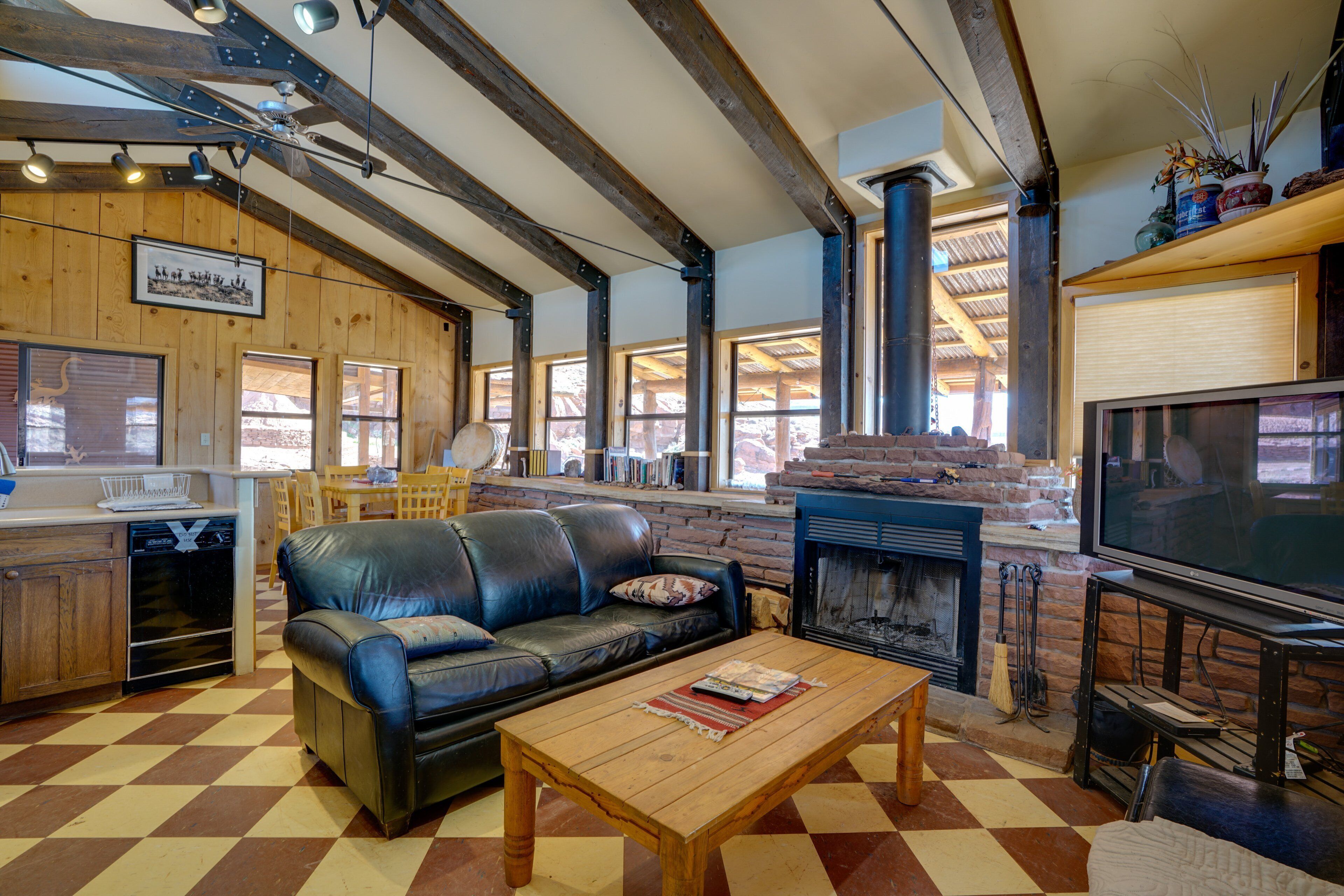 A living room with a fireplace, a television, a sofa, and a wooden coffee table.