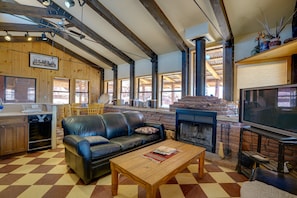 A living room with a fireplace, a television, a sofa, and a wooden coffee table.
