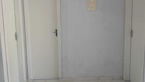 A room with white tiled flooring, two white doors, and a ceiling light fixture. - House 5 minutes from the Mozambique dunes trail (Florianópolis)