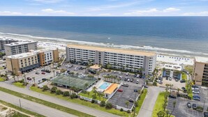 Un hotel con piscina, estacionamiento y vistas a la playa y al océano.