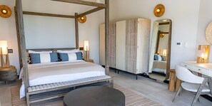 Un dormitorio con cama con dosel, mesitas de noche, un espejo, un escritorio y una silla.