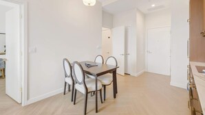 Et spiseområde med et bord og stole, en lampe over og en dør til et andet rum.