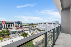 A high-rise building with a view of a cityscape, including a colorful mural and a modern building with a geometric facade. - Chic Miami Apt Pool, Gym & Sleeps 4 (Miami)