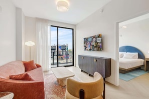 A modern hotel room with a sofa, a dining table, a cabinet, and a bed. - Chic Miami Apt Pool, Gym & Sleeps 4 (Miami)