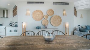 A dining area with a wooden table, chairs, and a central decorative bowl. - Seastar: Luxury 2-Bedroom Ocean-View Suite with Private Pool, Antigua (Urlings)