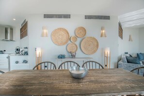 A dining area with a wooden table, chairs, and a central decorative bowl. - Seastar: Luxury 2-Bedroom Ocean-View Suite with Private Pool, Antigua (Urlings)