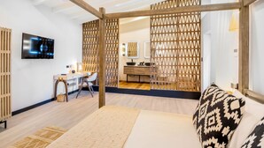 Una habitación moderna con una cama, un escritorio y un televisor.