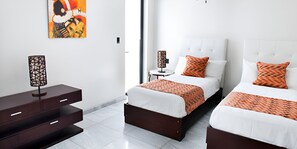 A modern hotel room with two beds, a nightstand, a lamp, and a painting on the wall. - Beachcomber: Luxury 3-Bedroom Beach House with Private Pool, Antigua (Urlings)