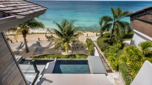 Un complexe hôtelier doté d’une piscine, de palmiers et offrant une vue sur l’océan.