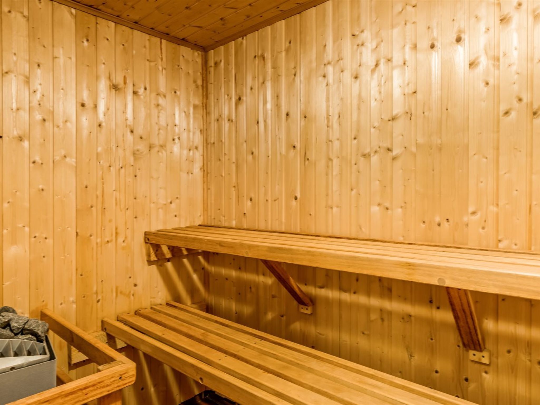 Un sauna avec des murs et des bancs en bois.