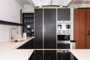 A modern kitchen with a black backsplash, stainless steel appliances, and a white countertop. - Beach House 3: Luxury 3-Bedroom Beach House with Private Pool, Antigua (Urlings)