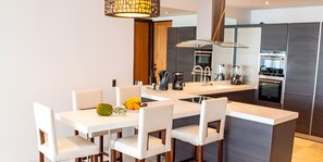 A modern kitchen with white countertops, stainless steel appliances, and a central island with seating. - Beach House 5: Luxury 3-Bedroom Beach House with Private Pool, Antigua (Urlings)