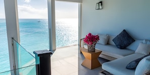 A balcony with a glass railing overlooking a pool and the sea. - Ocean Azul: Luxury 2-Bedroom Villa Overlooking Darkwood Beach, Antigua (Urlings)
