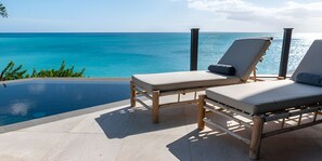A poolside area with two lounge chairs and a view of the ocean. - Oceanview 2BR Villa with Private Pool & Panoramic Balconies (Urlings)
