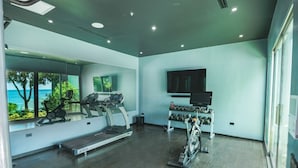 Un gimnasio moderno con equipo de ejercicio, cinta de correr y un soporte para pesas.