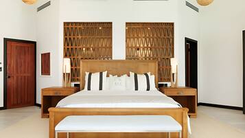 A bedroom with a wooden bed, two nightstands, a bench, a wooden partition, and a door.