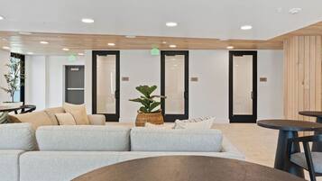 A modern waiting area with a sectional sofa, a round table, and a potted plant.