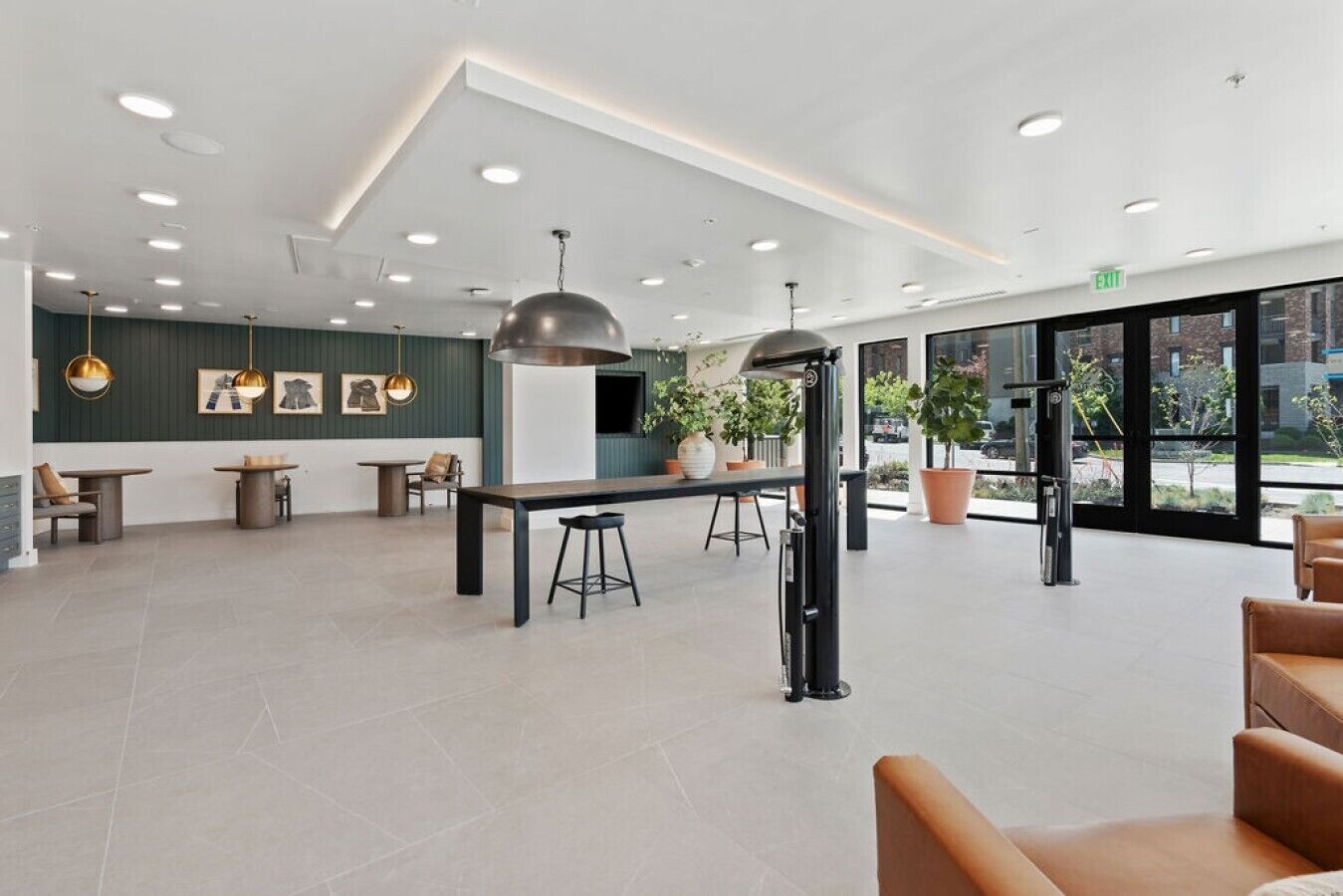 A spacious lobby with a reception desk, seating area, and large windows offering a view of the outdoors.