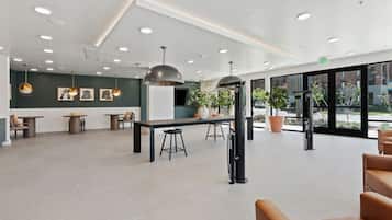 A spacious lobby with a reception desk, seating area, and large windows offering a view of the outdoors.